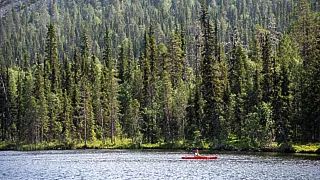 Ein Paddler auf dem Kesanki-See in Akaslompolo, Kolari, Lappland in Nordfinnland, im Juli 2021 während einer Hitzewelle.