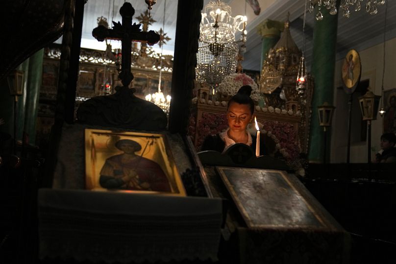 Worshippers hold candles as they attend Mass at the Church of St George on the island of Gokceada, April 2023