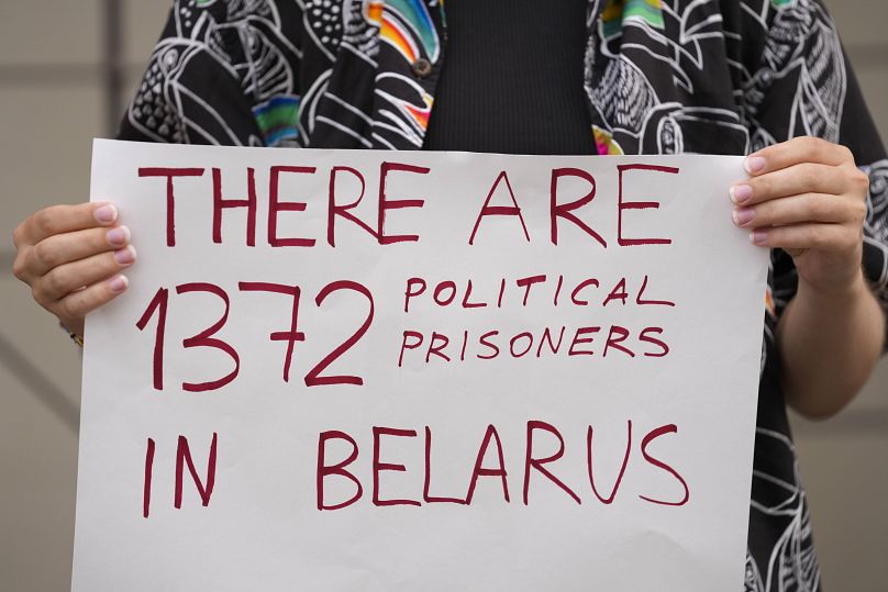 A woman holds a banner during a protest against extradite to Belarus a prominent critic of the authoritarian government in Minsk, Andrei Hniot. 