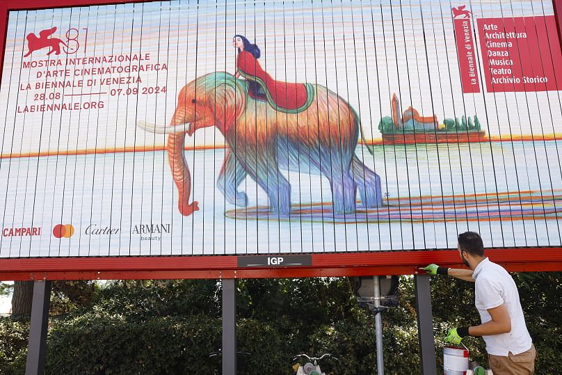 Workers paint signage for the 81st edition of the Venice Film Festival in Venice, Italy.