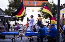 Supporters of the far-right Alternative for Germany party, or AfD, hold German national flags as they attend an election campaign rally of the party for upcoming state electio