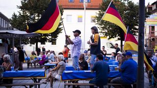 Supporters of the far-right Alternative for Germany party, or AfD, hold German national flags as they attend an election campaign rally of the party for upcoming state electio