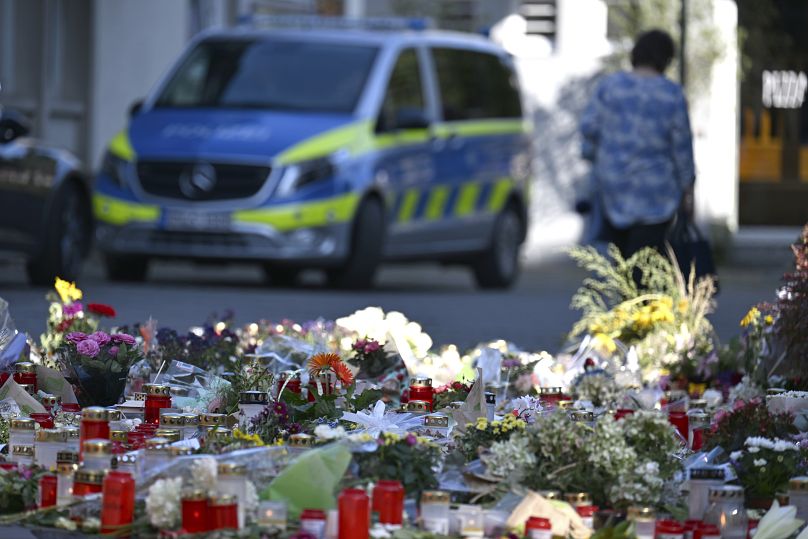 Flowers and candles are laid near the scene of a deadly knife attack during a festival, in Solingen, Germany, Wednesday, Aug. 28, 2024.