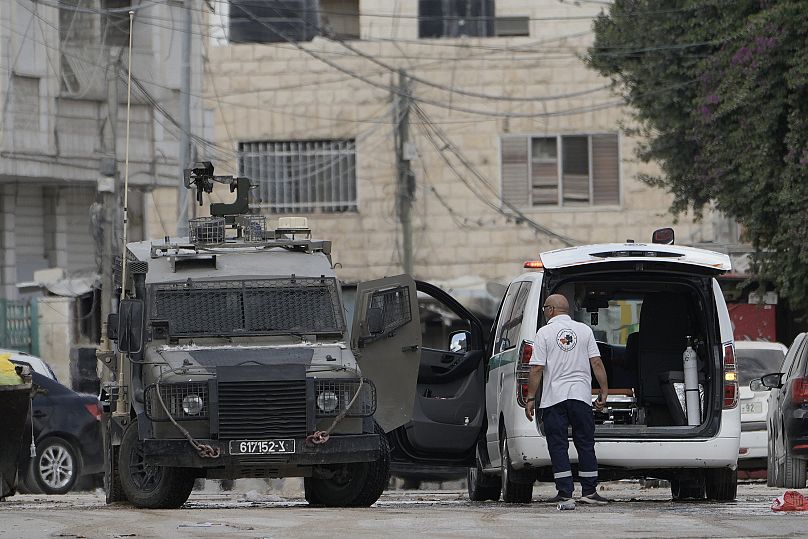 Members of the Israeli forces inside an armoured vehicle check an ambulance during a military operation in the West Bank city of Jenin.