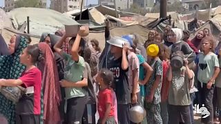 Des enfants palestiniens font la queue pour obtenir des repas dans le camp de réfugiés de Deir al-Balah