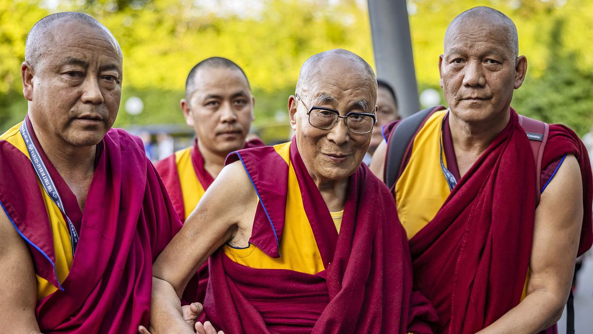 A dalai láma, a tibeti indiai emigrációban élő buddhisták vallási vezetője (középen) a Zürich melletti Opfikon egyik szállodájához érkezik 2024. augusztus 23-án.