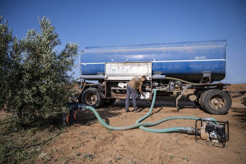 Dimitris Papadakis Jr collega il serbatoio di acqua del camion a un piccolo generatore, nel villaggio di Nea Silata nella penisola di Halkidiki 