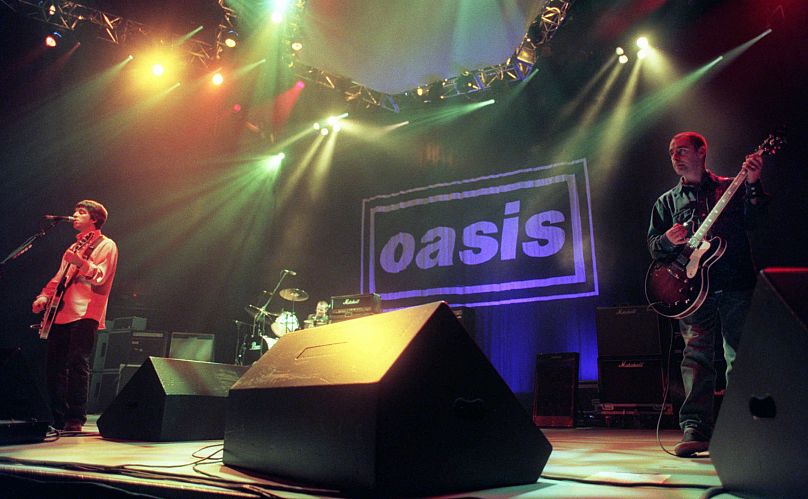 Noel Gallagher, left, Alan White, center, and Paul Authurs of the band Oasis perform for the crowd at the English band's opening date in the United States, 1996