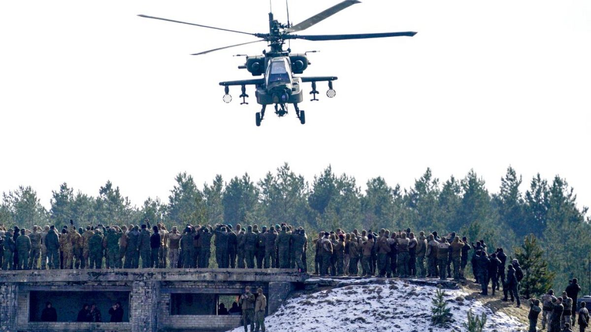 A U.S. Boeing AH-64 Apache attack helicopter flies during the NATO military exercises Crystal arrow 2022 at the Adazi military range, Latvia, Friday, March 11, 2022. About 2,8