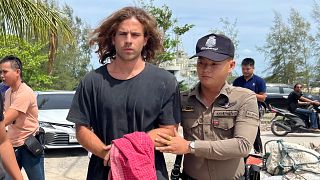 FILE - A Thai police officer escorts Spanish Daniel Sancho Bronchalo