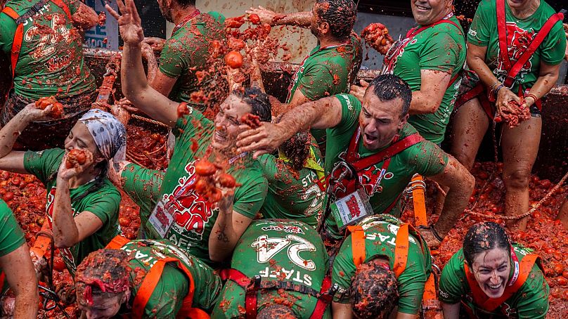 Foliões participam na batalha de tomates vestidos a rigor com as t-shirts oficiais do evento