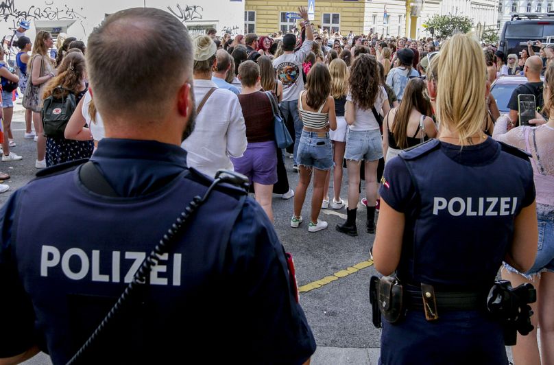 Police officers stand near a gathering of Swifties in Vienna.