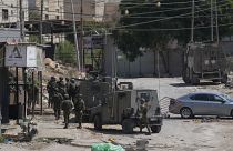 Members of Israeli forces patrol a street during a military operation in the West Bank refugee camp of Al-Faraa, Wednesday, Aug. 28, 2024.