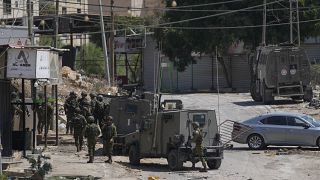 Members of Israeli forces patrol a street during a military operation in the West Bank refugee camp of Al-Faraa, Wednesday, Aug. 28, 2024.