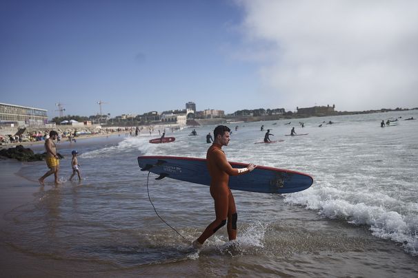 Surf Church's pastor Samuel Cianelli, walks into the Atlantic Ocean to surf with his congregation in Matosinhos beach in the suburbs of Porto, Portugal on Aug. 18, 2024.