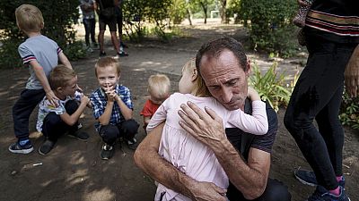 A father hugs his daughter, with his other children nearby, as the family waits to be evacuated in Pokrovsk, Donetsk region, Ukraine, Aug. 23, 2024.