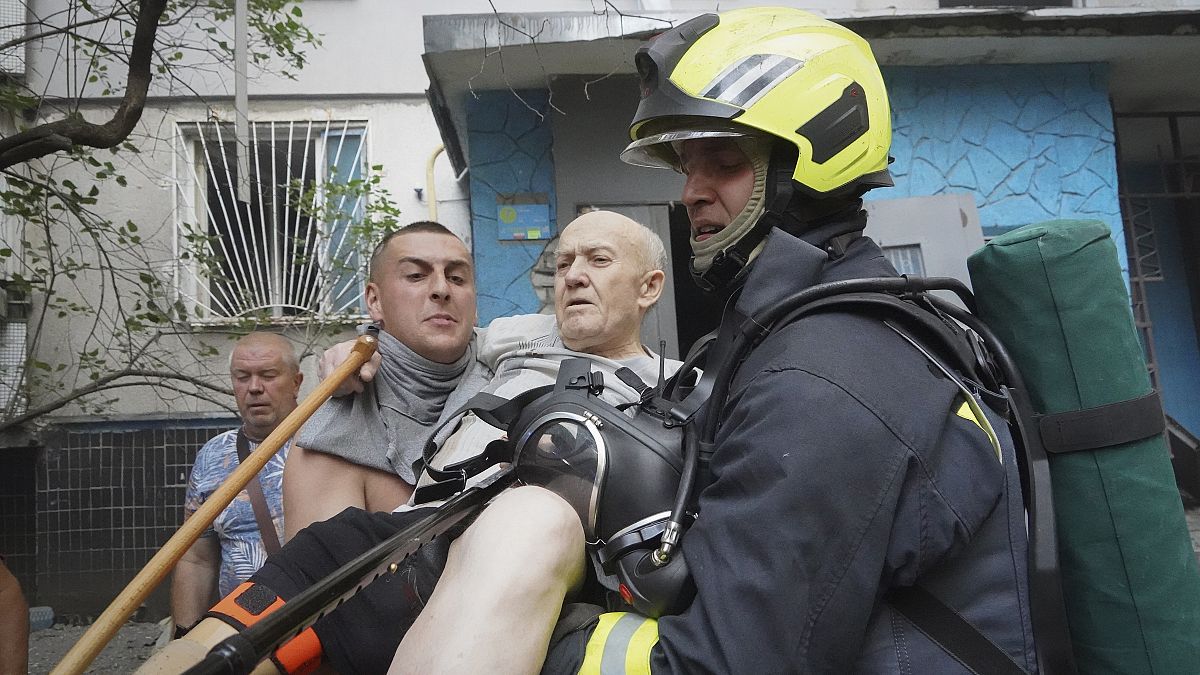 Soccorritori trasportano un anziano dopo che una bomba russa ha colpito un condominio a Kharkiv in Ucraina (30 agosto 2024)