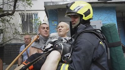 Soccorritori trasportano un anziano dopo che una bomba russa ha colpito un condominio a Kharkiv in Ucraina (30 agosto 2024)