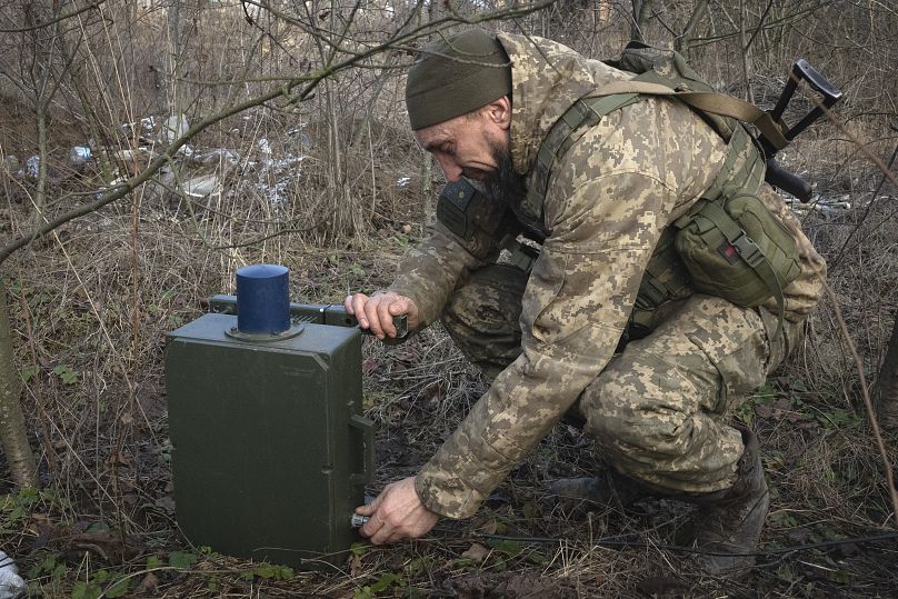 Украинский военный устанавливает блок системы РЭБ для борьбы с российскими дронами: район Бахмута, январь 2024 г.