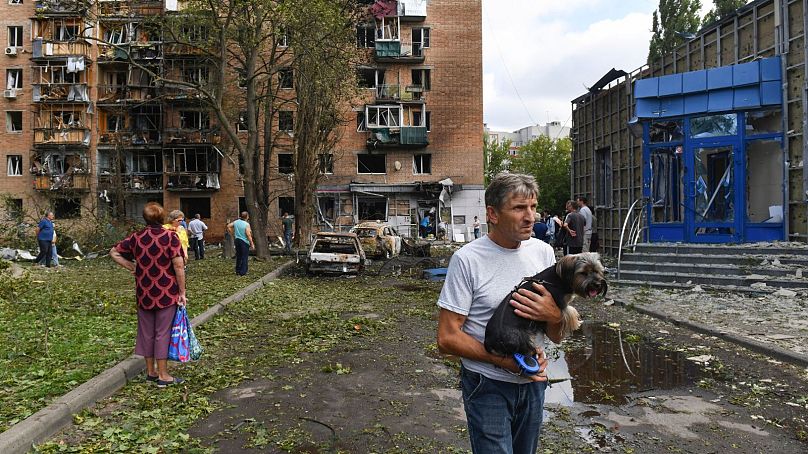 Residentes abandonam um edifício de apartamentos danificado por um bombardeamento das forças ucranianas em Kursk.