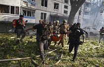 Rescuers carry a body of a resident killed in the Russia's guided air bomb strike in Kharkiv