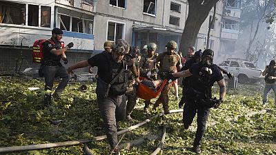 Rescuers carry a body of a resident killed in the Russia's guided air bomb strike in Kharkiv