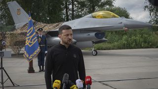 El presidente de Ucrania, Volodymyr Zelenskyy, responde a las preguntas de la prensa delante de un caza F-16 en un lugar no revelado de Ucrania, el 4 de agosto de 2024.