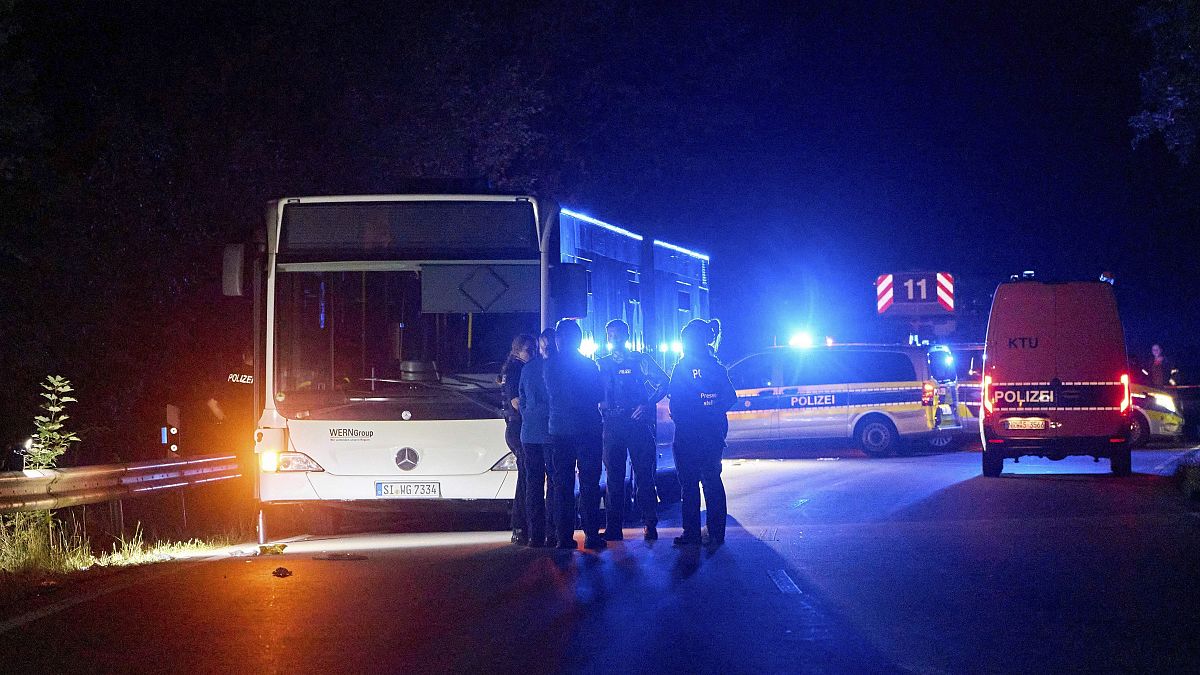 Полицейские стоят у автобуса, следующего по специальному маршруту на городской фестиваль в Зигене, 30 августа 2024 года.