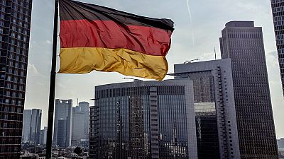 A German flag waves in front of the buildings of the banking district in Frankfurt, Germany, Friday, Aug. 30, 2024. (AP Photo/Michael Probst)