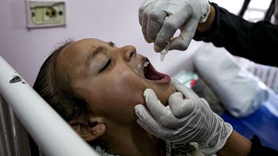 A health worker administers a polio vaccine to a child at a hospital in Khan Younis, August 31, 2024