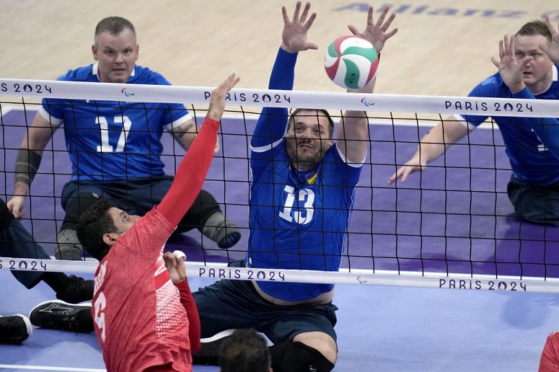 Dmytro Melnyk of Ukraine tries to block the ball during the men's preliminary round Sitting Volleyball game against Iran at the 2024 Paralympics, Friday, Aug. 30, 2024