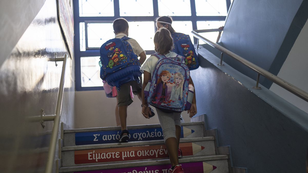 Des élèves montent les escaliers pour entrer en classe lors de leur premier jour d'école au Pirée, le 12 septembre 2022.