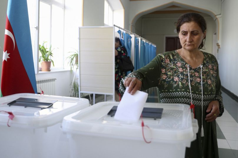 Una mujer deposita su voto en un colegio electoral durante las elecciones anticipadas al parlamento Milli Mejlis en Bakú, Azerbaiyán, el domingo 1 de septiembre de 2024.