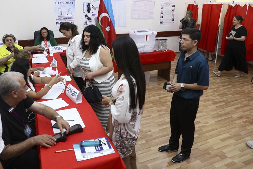 Women line up to cast ballots at a polling station during a snap election in the Milli Mejlis parliament in Baku, Azerbaijan, Sunday, Sept. 1, 2024.