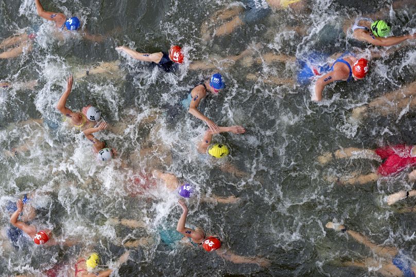 Competitors swim in the Seine River during the women's individual triathlon competition at the 2024 Summer Olympics, Wednesday, July 31, 2024, in Paris, France.