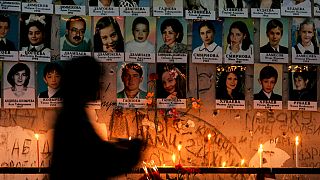 Una donna davanti al muro con i ritratti delle vittime della scuola di Beslan a un anno dalla strage, 2 settembre 2005