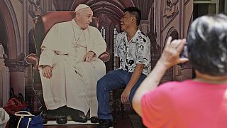 A man has his photo taken with a cutout of Pope Francis displayed at Jakarta Cathedral ahead of his visit to Indonesia from Sept. 3-6, in Jakarta, Indonesia, Sunday, Sept. 1, 