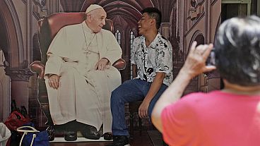 A man has his photo taken with a cutout of Pope Francis displayed at Jakarta Cathedral ahead of his visit to Indonesia from Sept. 3-6, in Jakarta, Indonesia, Sunday, Sept. 1, 