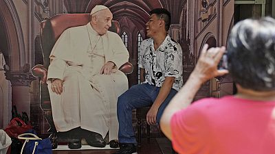 A man has his photo taken with a cutout of Pope Francis displayed at Jakarta Cathedral ahead of his visit to Indonesia from Sept. 3-6, in Jakarta, Indonesia, Sunday, Sept. 1, 