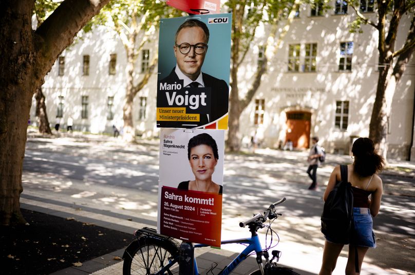 Election campaign posters of the Christian Democratic Union party, CDU, with top candidate Mario Voigt and of the Sahra Wagenknecht Alliance are displayed at a lamp post in Je