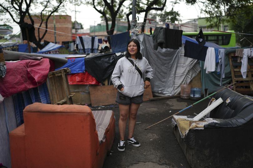 La migrante Carolina Arriaga è in piedi in un accampamento di tende per migranti a Città del Messico