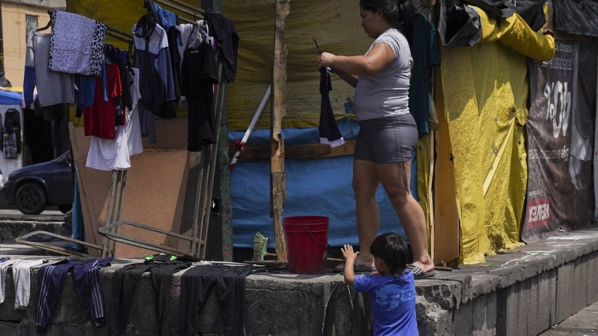 La migrante venezuelana Osdeigly Granadillo stende i panni ad asciugare in un accampamento di tende per migranti allestito nei dintorni di Città del Messico