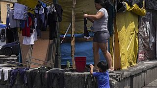 Osdeigly Granadillo pendura as suas roupas para secar num acampamento improvisado nos arredores da paróquia católica de Santa Cruz e La Soledad