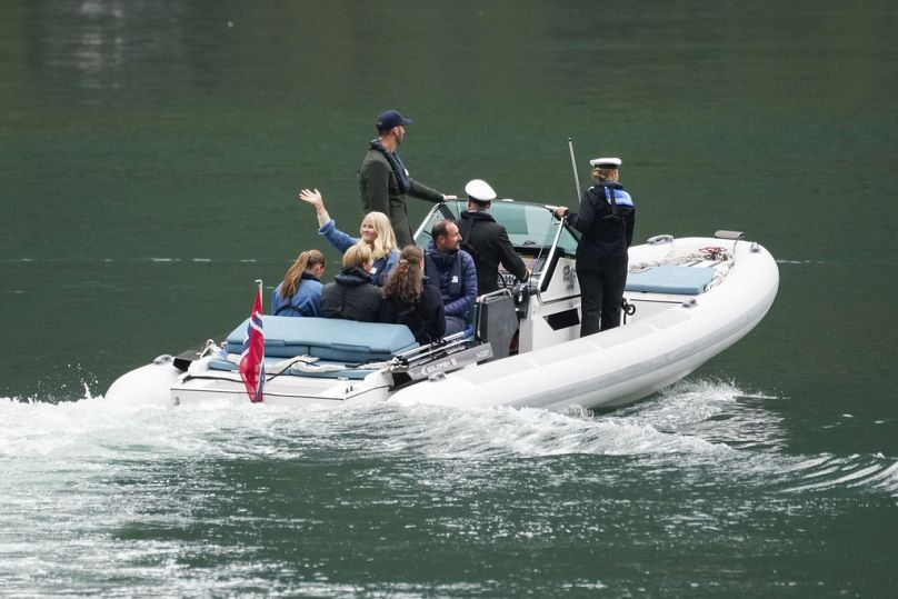 Norway's Crown Prince Haakon, 3rd right, Crown Princess Mette-Marit, center left waving, and other royal family members travel to Geiranger, Norway, Friday Aug. 30, 2024.