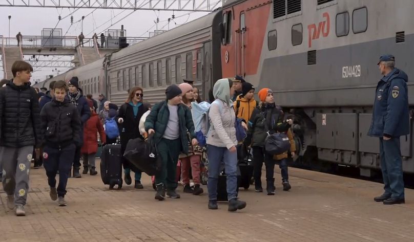 Vendredi 22 mars 2024, des enfants déportés des colonies limitrophes de l'Ukraine montent à bord d'un train pour être transférés à Penza, à Belgorod, en Russie. 