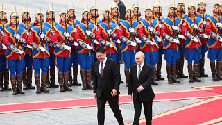 Russian President Vladimir Putin, right, walks with Mongolian President Ukhnaagiin Khurelsukh, left, during a welcoming ceremony at Sukhbaatar Square in Ulaan Bator, Mongolia.