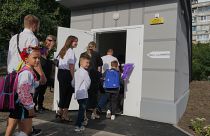 Schoolchildren and their parents enter an underground school on the first day at school in Kharkiv, Ukraine, Monday, Sept. 2, 2024. 