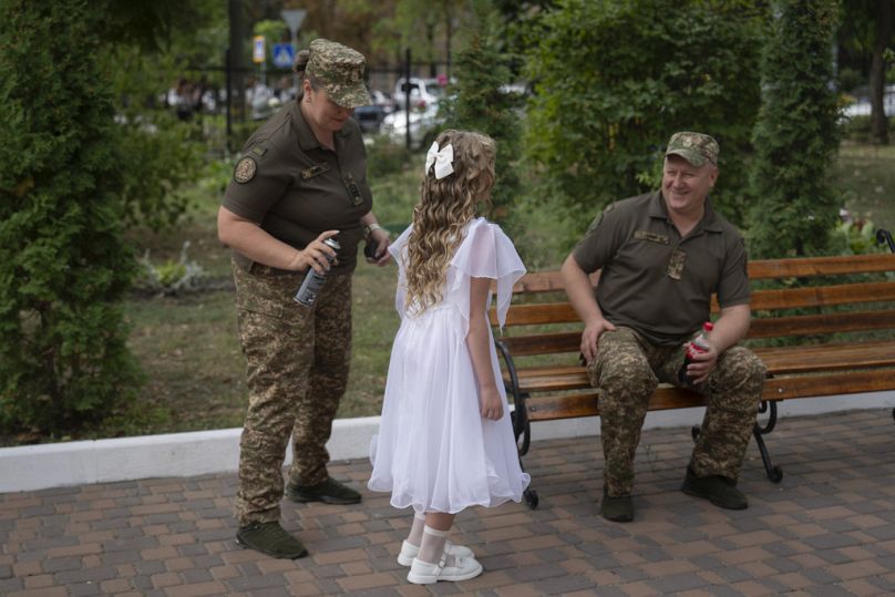 I genitori aiutano la figlia a prepararsi per il primo giorno di scuola in un liceo per cadetti a Kiev, Ucraina, 2 settembre 2024.