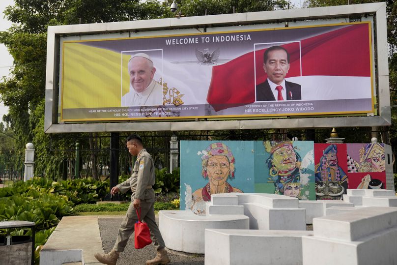 Cartel de bienvenida con retratos del Papa Francisco y del presidente indonesio Joko Widodo antes de la visita.