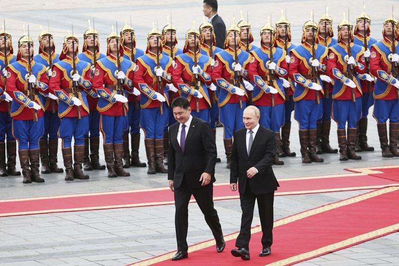 Vladimir Putin caminha com o presidente da Mongólia durante a cerimónia de boas-vindas na Praça Sukhbaatar em Ulaanbaatar, Mongólia, terça-feira, 3 de setembro 2024